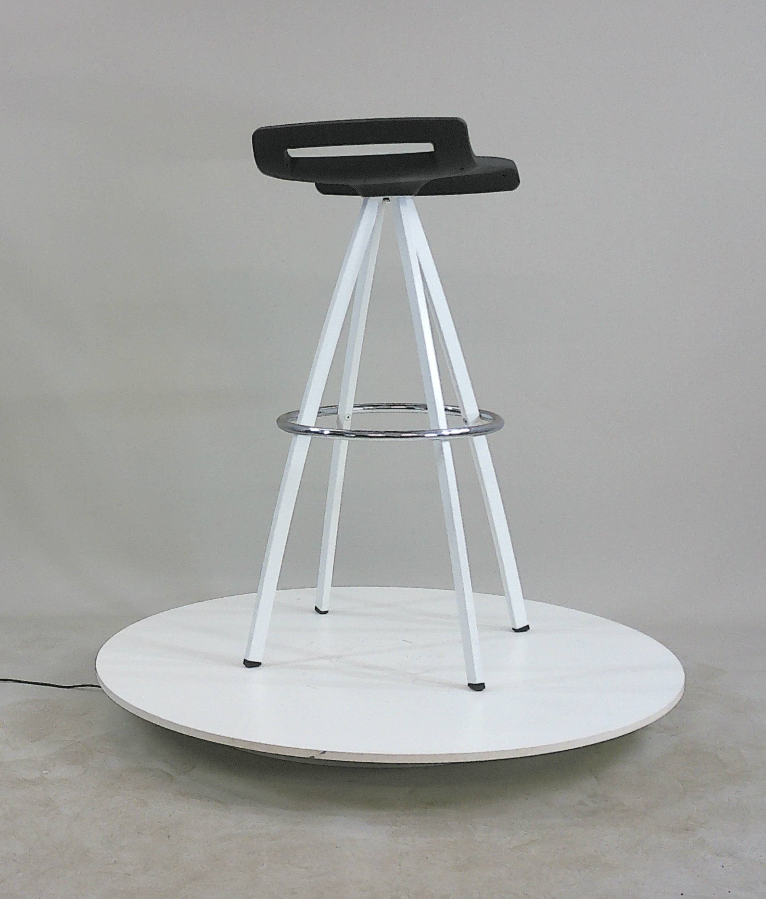 Bar stool sitting and an angle with white powder coated 4 leg base and black seat with low back